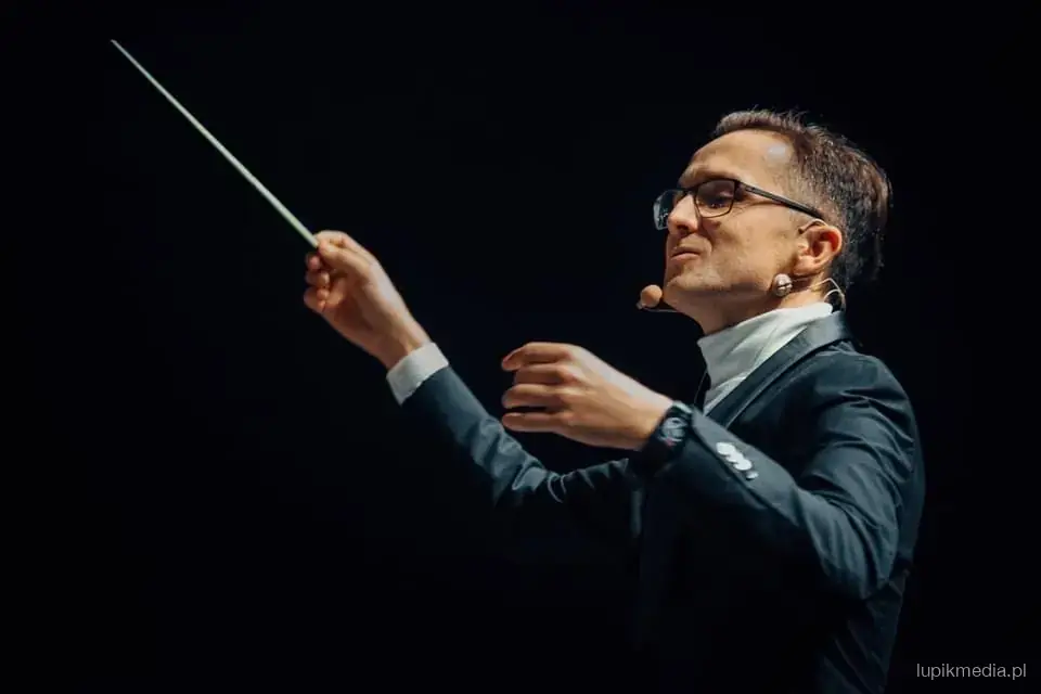 Wojciech Zwierniak z batutą, w świetle reflektora